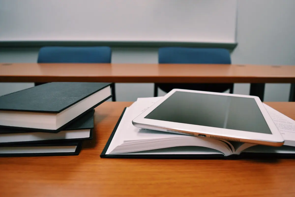 A tablet and books on a classroom desk