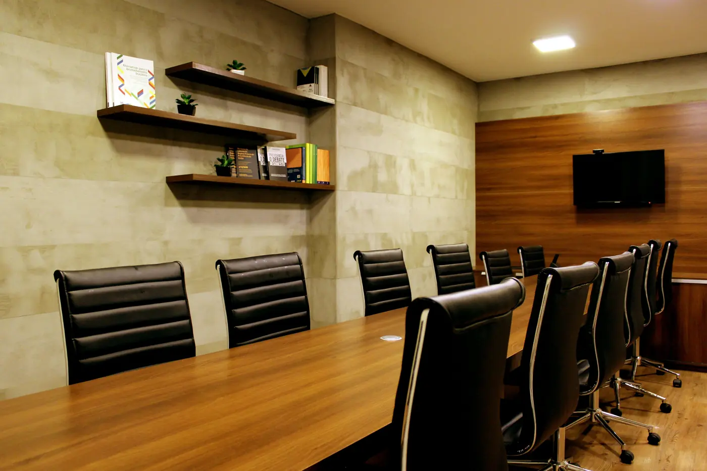 An empty boardroom with leather chairs around a long wooden table