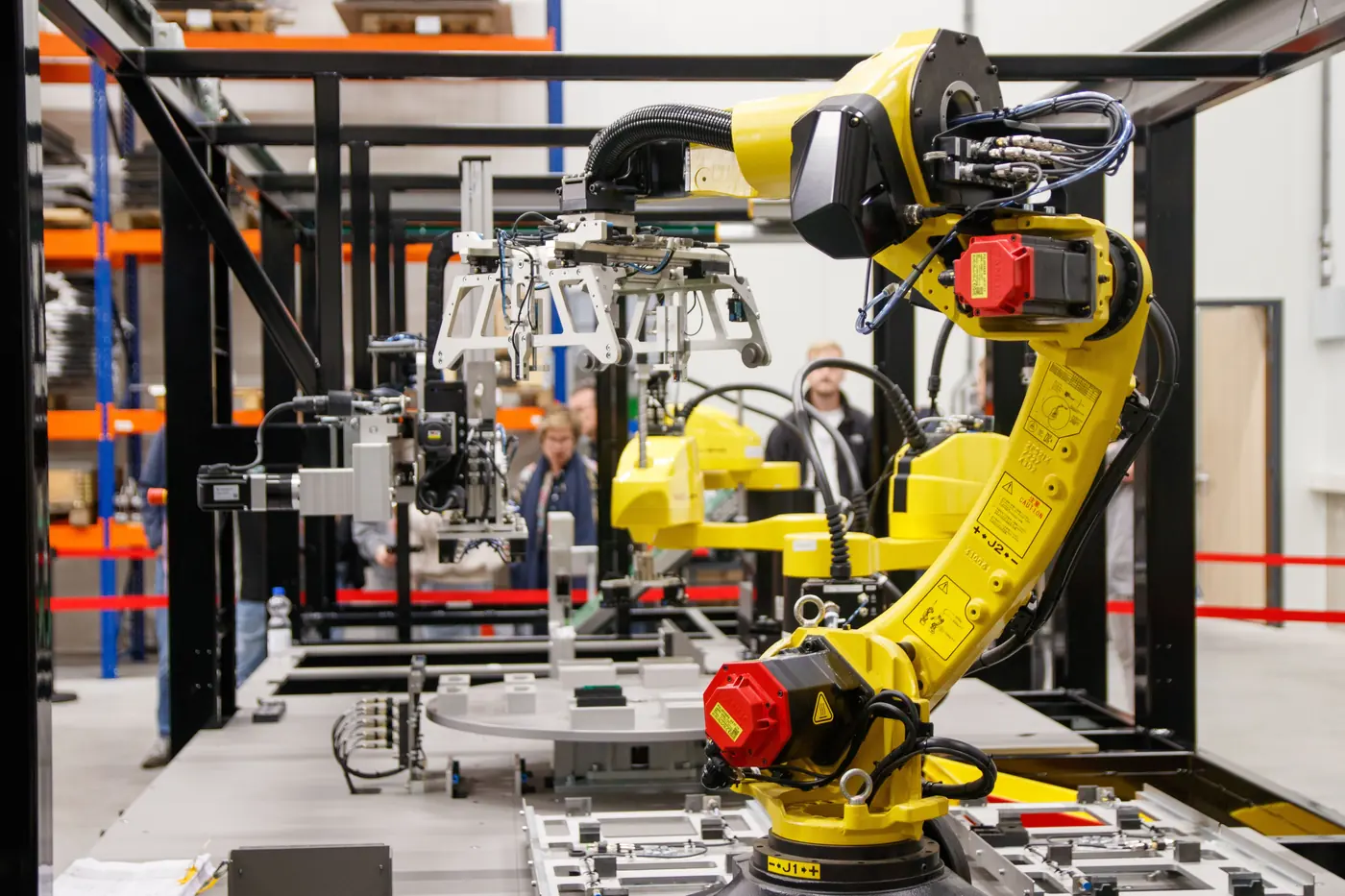 A yellow industrial robot arm on a manufacturing line