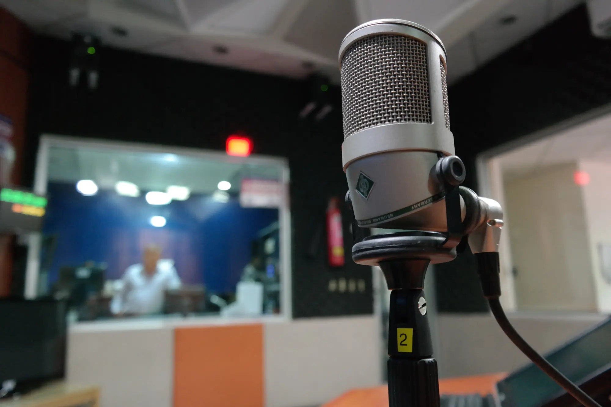 Professional voice artist recording multilingual voice-over in studio with microphone and headphones